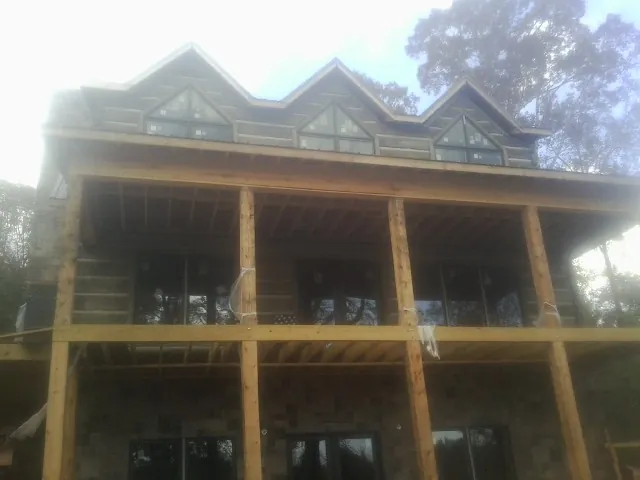 Dormers and porch framing on a large log home under construction — Roof Coating work by our crew in New Kensington