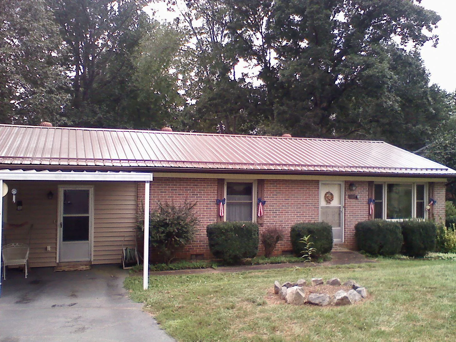 Bronze metal roof and carport on a brick ranch home — Roof Repair work by our crew in New Kensington